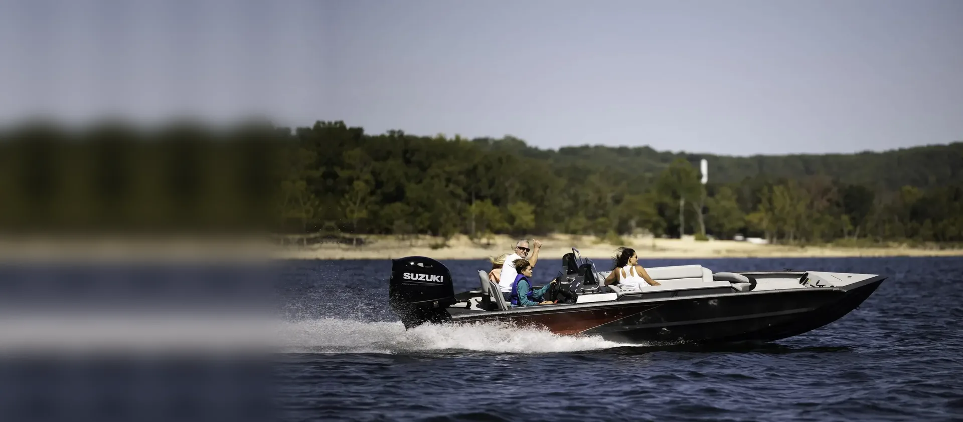 Aluminum bass boat with a Suzuki outboard running across open water