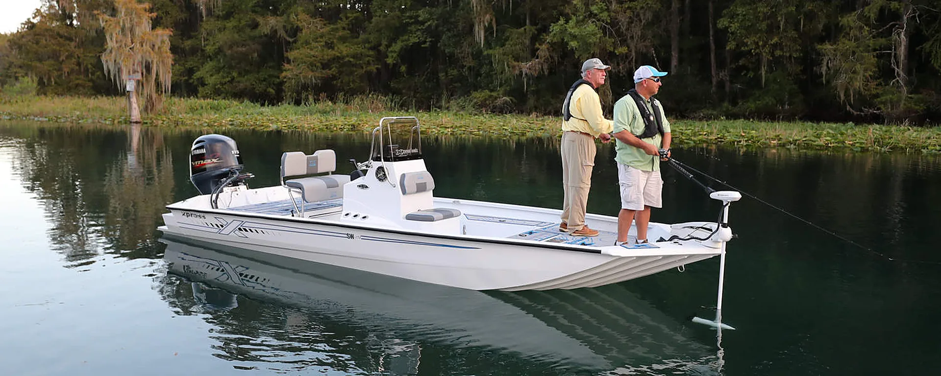 Two anglers fishing from a white bay boat on a calm Texas river