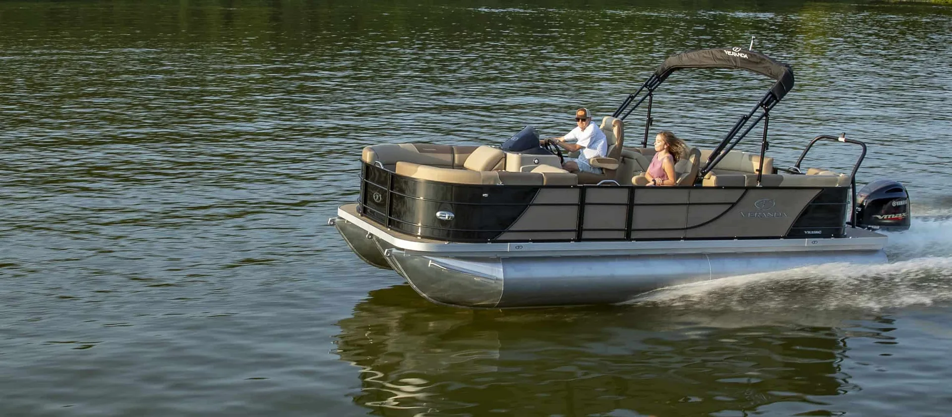 Pontoon boat with people aboard running on open water